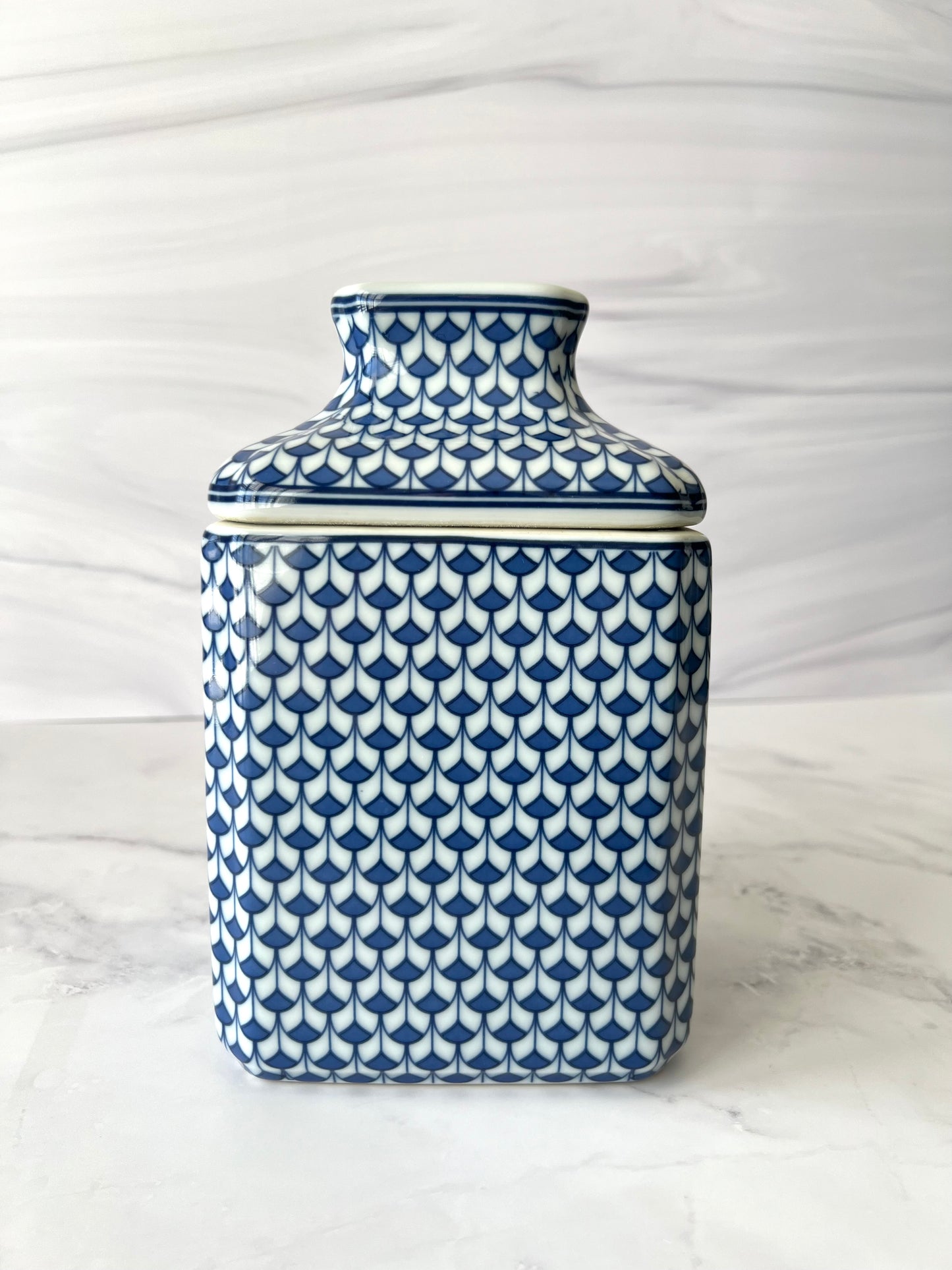 Blue and white patterned ceramic tissue box on a marble surface