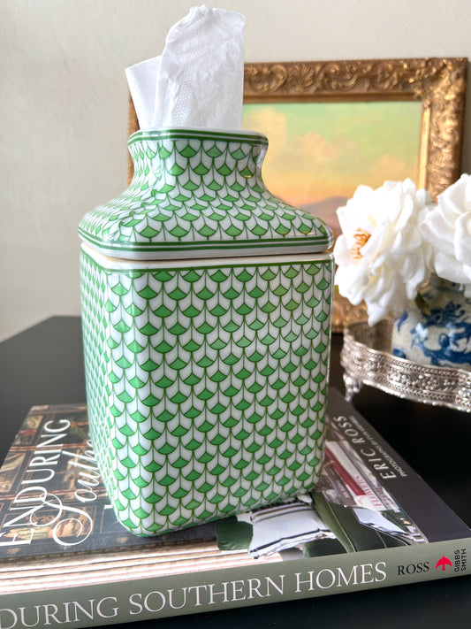 Green and white fish scale patterned tissue box on a book with a blurred background