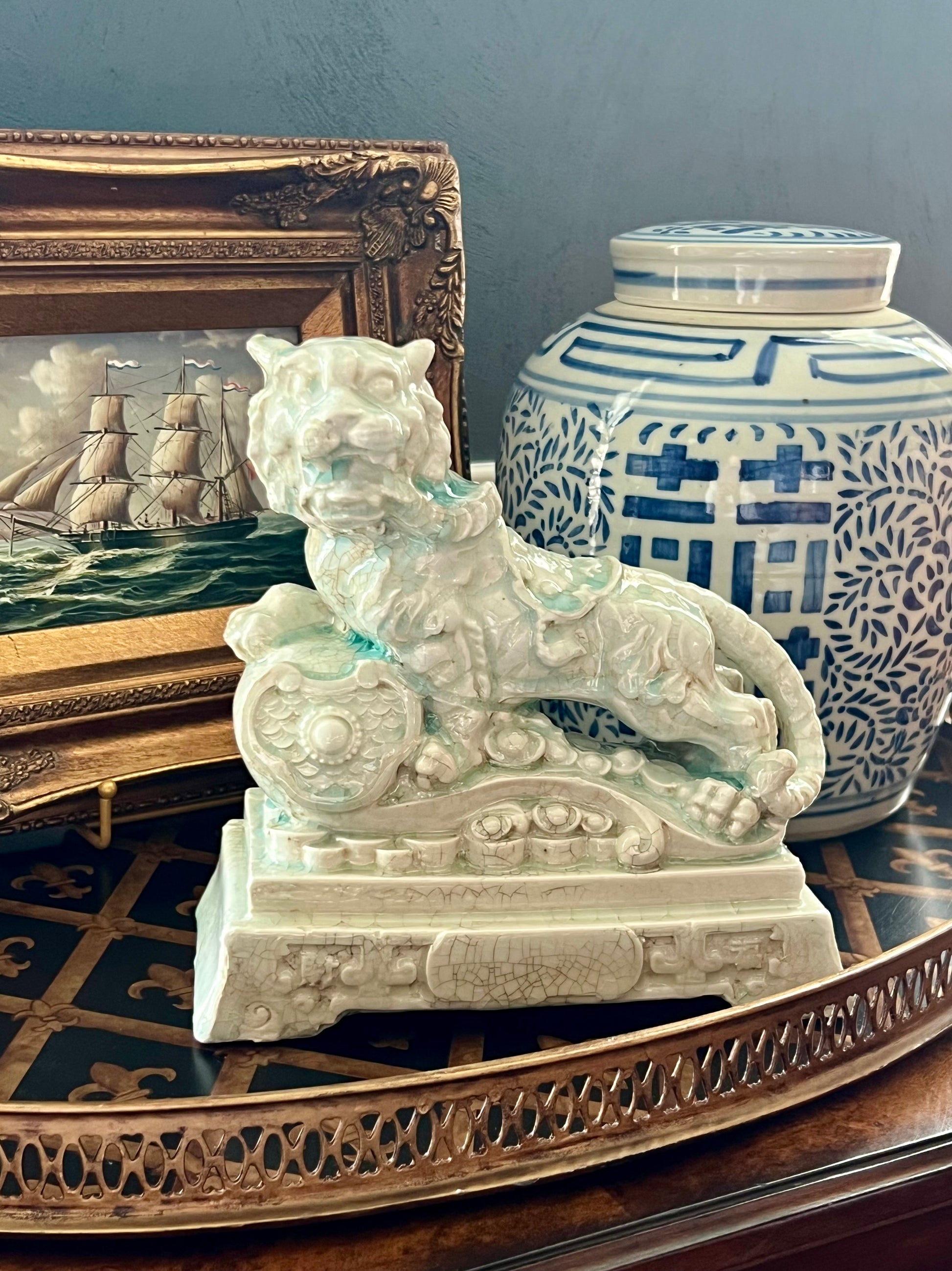 Celadon tiger guardian figurine with crackle glaze and ornate sculpted details.