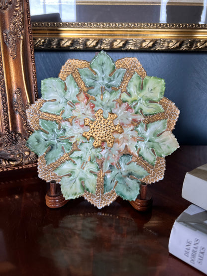 Antique German porcelain molded leaf cabinet plate with hand painted green leaves, gilt accents, and high relief botanical design displayed on a wooden stand.