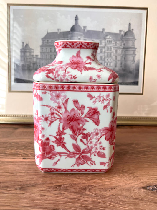 Pink and white porcelain floral tissue cover on a wooden surface