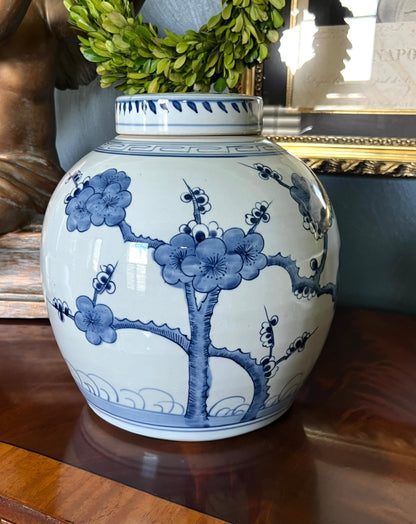 Blue and white hand-painted cherry blossom ginger jar on a wood console.