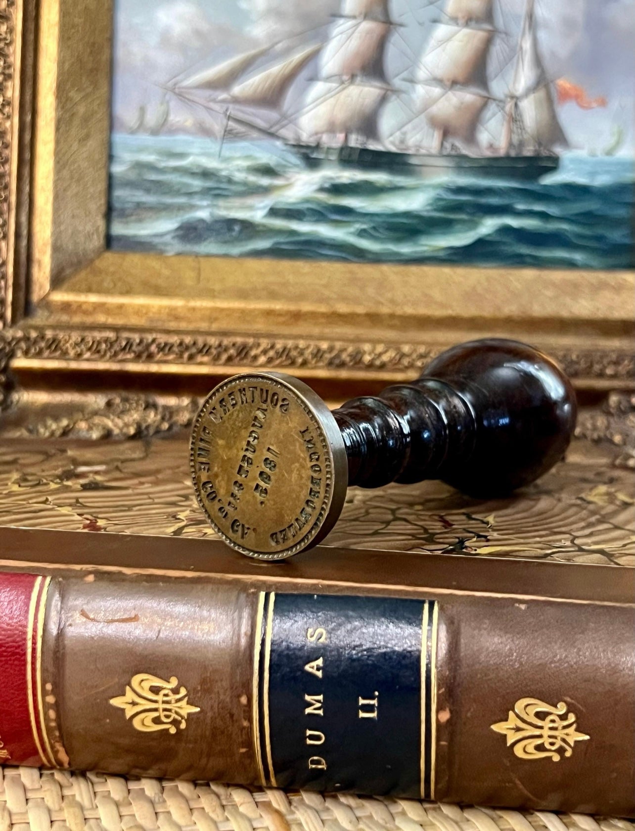 Antique brass wax seal stamper from Southern Pine Co. of Georgia dated 1895 with wooden handle and natural patina, styled on vintage books