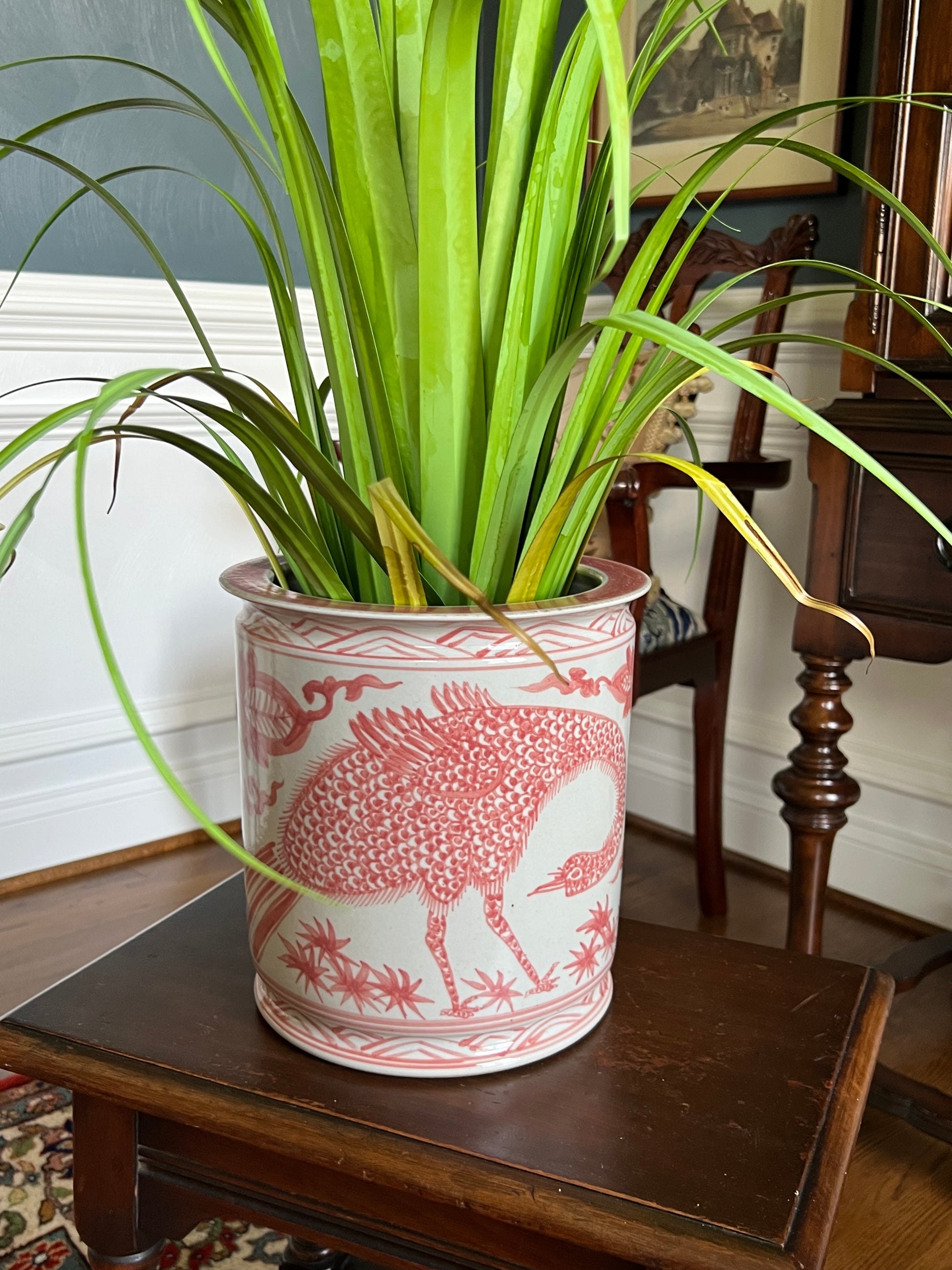 A beautifully detailed red peacock porcelain cachepot with classic chinoiserie motifs. Perfect for florals, orchids, or decorative styling.