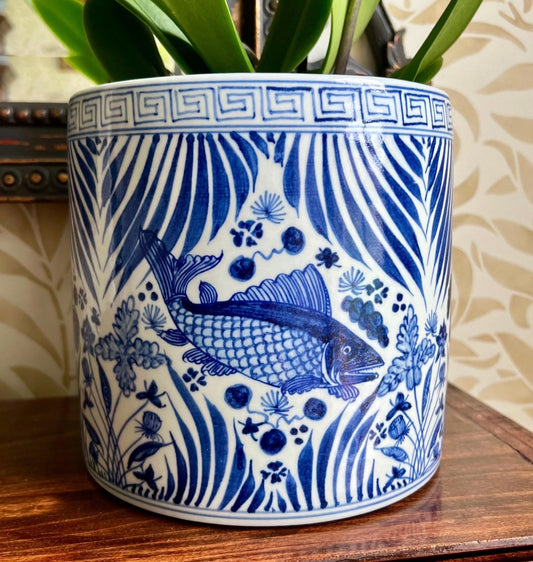 Blue and white porcelain planter with fish motif and botanical patterns.