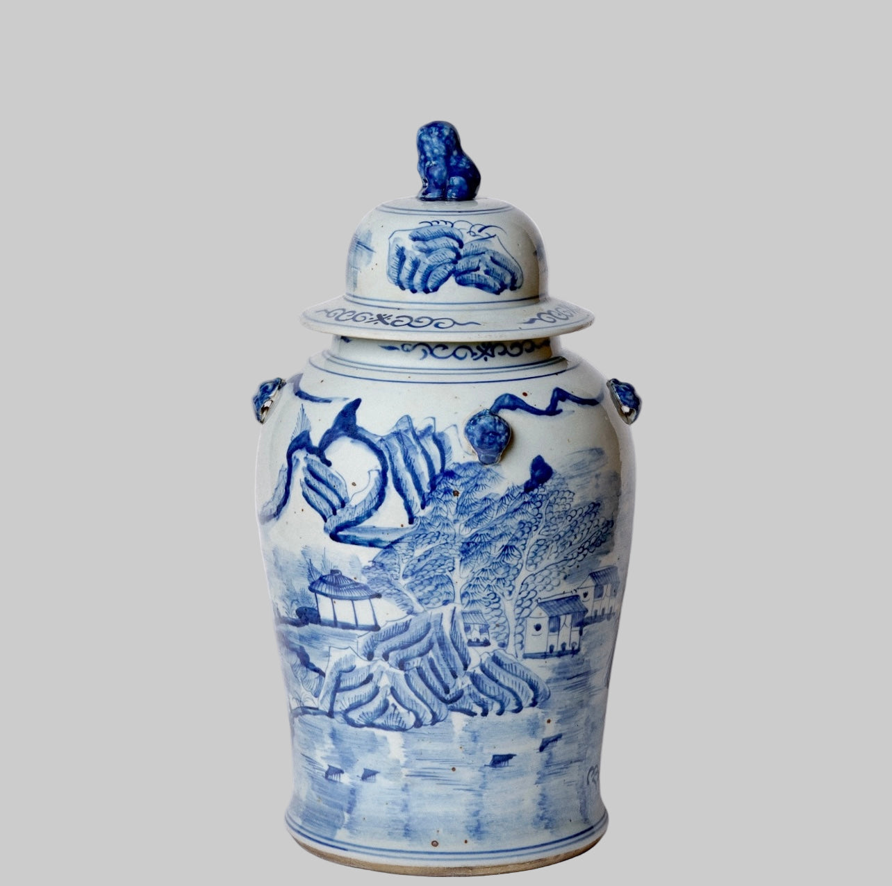 Blue and white porcelain ginger jar with hand-painted landscape and foo dog lid.