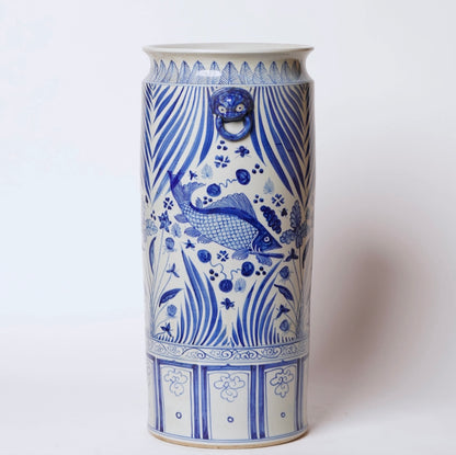 Blue and white porcelain koi fish umbrella stand with aquatic foliage and decorative ring handles.